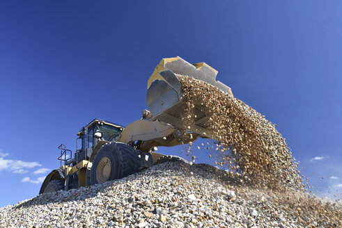 Wheel loader loading stones in gravel pit - LYF000579