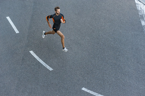 Mann läuft auf Straße mit Markierungen, lizenzfreies Stockfoto