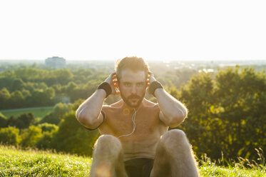 Man doing situps on a meadow - DIGF001095