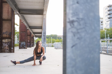 Young woman stratching under bridge - SIPF000813