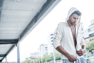 Fit young man wearing hooded jacket in city - SIPF000817