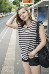 Portrait of young woman waiting at bus stop - TAMF000612