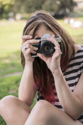 Junge Frau, die Fotos von Betrachtern macht - TAMF000613