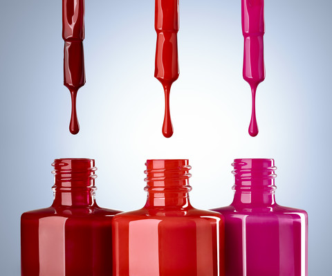 Close up of nail polish on blue background, red, drop stock photo