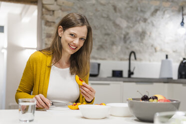 Woman in kitchen preparing fruit salad - DIGF001145