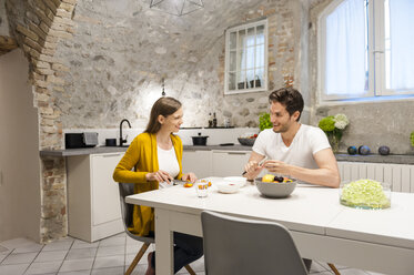 Couple in kitchen preparing fruit salad - DIGF001147