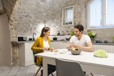 Ehepaar in der Küche bei der Zubereitung von Obstsalat - DIGF001147