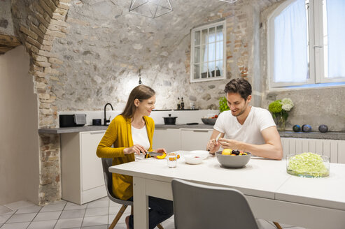 Ehepaar in der Küche bei der Zubereitung von Obstsalat - DIGF001148