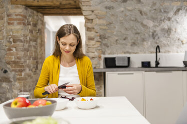 Frau in der Küche bei der Zubereitung von Obstsalat - DIGF001152