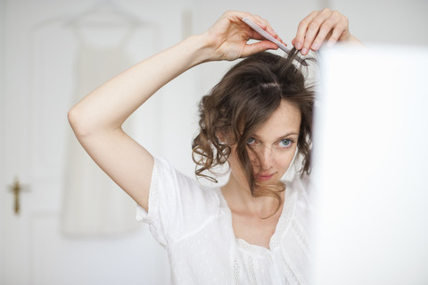 Frau macht sich zu Hause die Haare, lizenzfreies Stockfoto