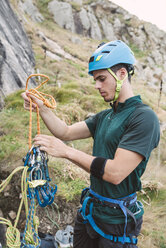 Young man preparing climbing equipment - RAEF001457