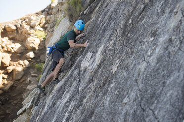 Young man climbing a rock wall - RAEF001479