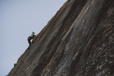 Junger Mann klettert an einer Felswand - RAEF001485