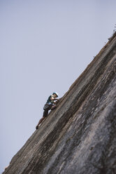 Young man climbing a rock wall - RAEF001486