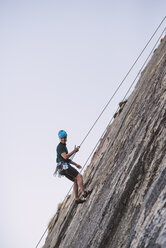 Junger Mann klettert an einer Felswand - RAEF001488