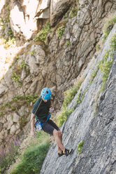Young man climbing a rock wall - RAEF001491