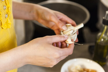 Frau in Küche hält Knoblauch - DIGF001191