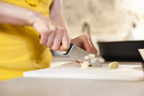 Woman in kitchen cutting peach - DIGF001195