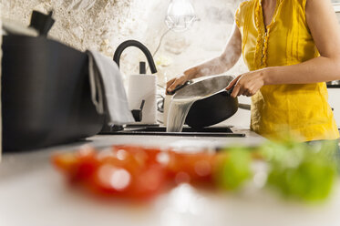 Frau in der Küche bei der Zubereitung von Spaghetti - DIGF001204