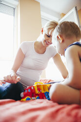 Schwangere Mutter und Sohn spielen auf dem Bett - ZEDF000315