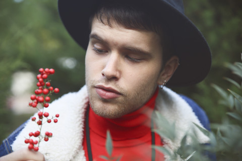 Young man looking at wild berries stock photo