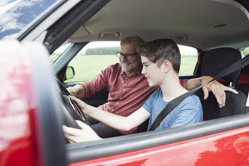 Vater unterrichtet Sohn beim Autofahren - RBF005151