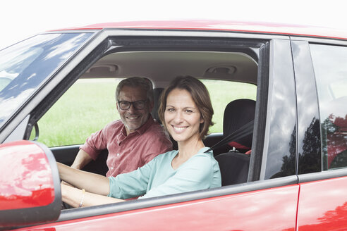 Porträt eines glücklichen reifen Paares im Auto - RBF005152