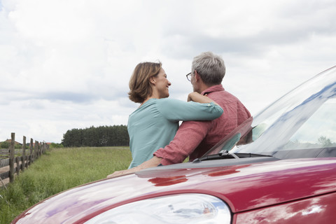 Lächelndes reifes Paar, das sich im Auto auf dem Lande ausruht, lizenzfreies Stockfoto