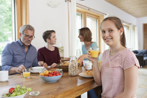 Porträt eines Mädchens beim Frühstück mit ihrer Familie zu Hause - RBF005159