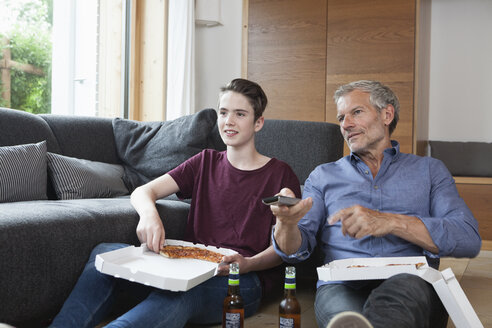 Vater und Sohn essen Pizza und sehen zusammen fern - RBF005172