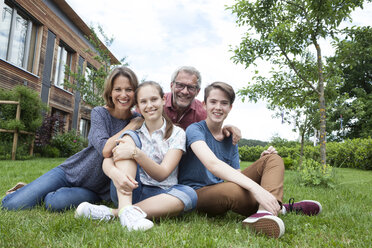 Porträt einer glücklichen Familie, die im Garten sitzt - RBF005191