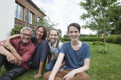 Porträt einer glücklichen Familie, die im Garten sitzt - RBF005192