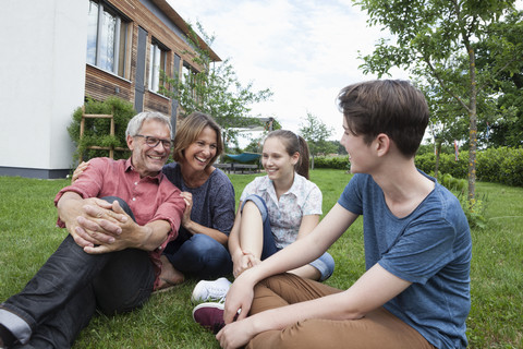 Glückliche Familie im Garten sitzend, lizenzfreies Stockfoto