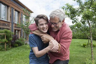 Playful father and son in garden - RBF005206