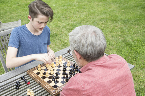 Vater und Sohn spielen Schach im Garten - RBF005207