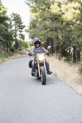 Man riding motorbike on open road - ABZF001137