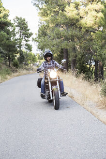 Mann fährt Motorrad auf offener Straße - ABZF001137