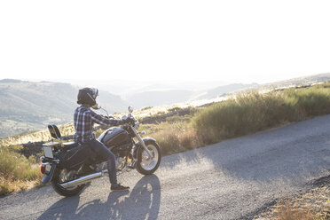 Mann auf seinem Motorrad in der Abenddämmerung - ABZF001145