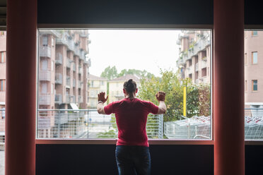 Rückansicht eines Mannes, der durch ein Fenster schaut - SIPF000826