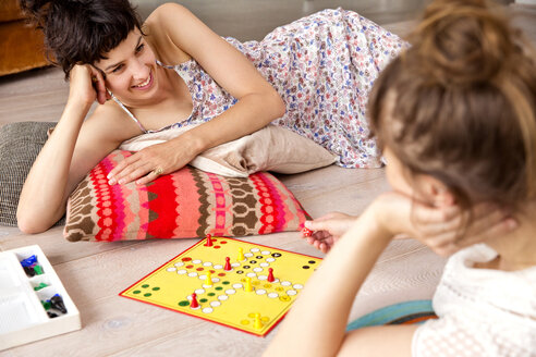 Zwei beste Freunde liegen zu Hause auf dem Boden und spielen Ludo - TSFF000112