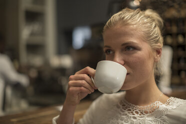 Junge Frau trinkt eine Tasse Kaffee in einem Cafe - ZEF010055