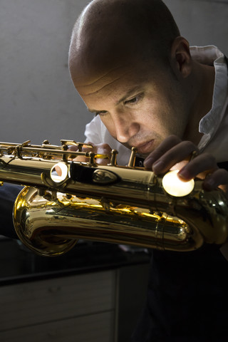 Instrumentenbauer bei der Reparatur eines Saxophons, lizenzfreies Stockfoto