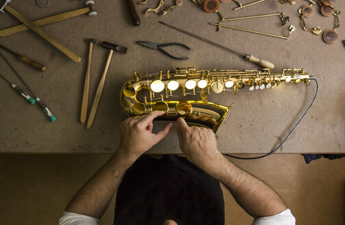 Instrumentenbauer bei der Reparatur eines Saxophons - ABZF001176