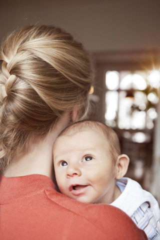 Baby schaut über die Schulter der Mutter, lizenzfreies Stockfoto