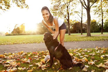 Frau auf einem Spaziergang mit ihrem Hund im Herbst - MFF003039