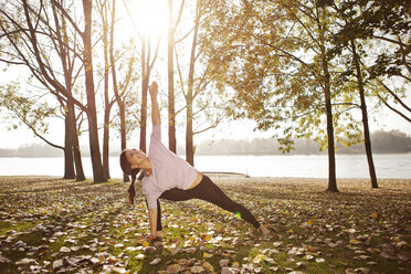 Frau in der Natur, die eine Yoga-Pose einnimmt - MFF003040