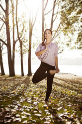 Frau in der Natur, die eine Yoga-Pose einnimmt - MFF003044