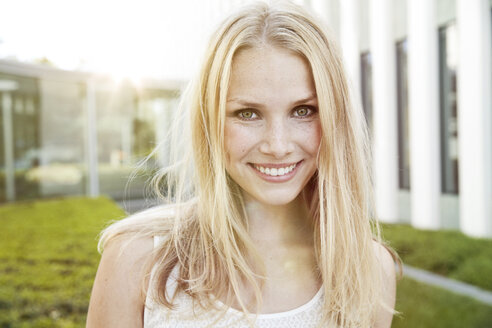 Porträt einer lächelnden jungen blonden Frau im Freien - MFF003081