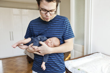 Father holding newborn son at home - MFF003130