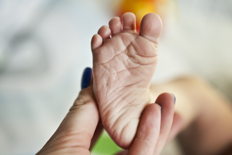 Hand hält den Fuß des Babys, lizenzfreies Stockfoto